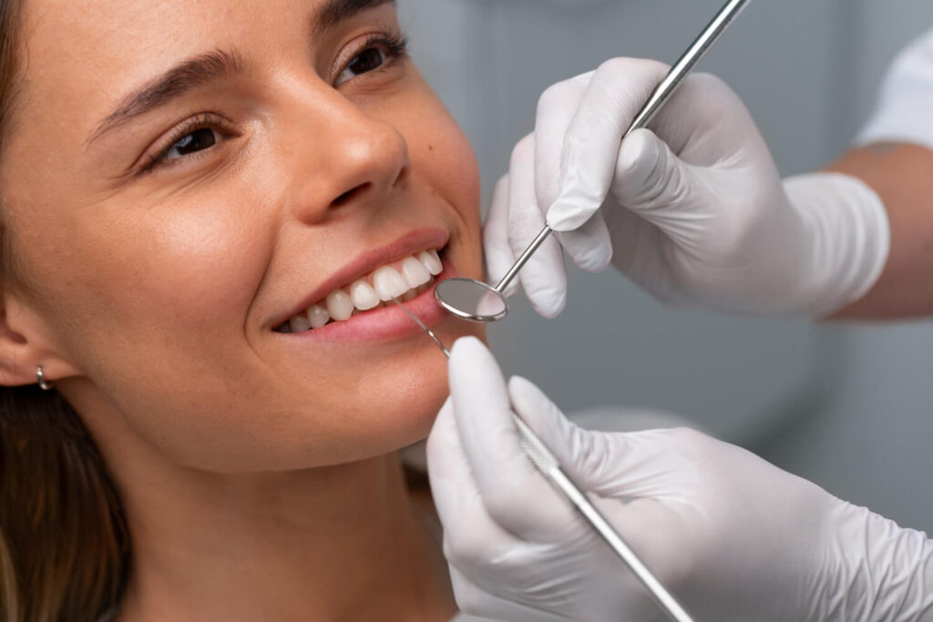 Dentista examina facetas de resina em paciente na Clínica Aliança Sergipe antes de iniciar clareamento dental.